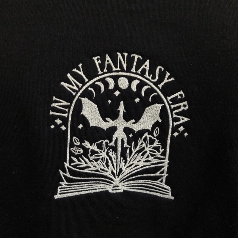 A cozy sweatshirt featuring the phrase "In my Fantasy Era" prominently displayed on the chest. Perfect for book lovers!