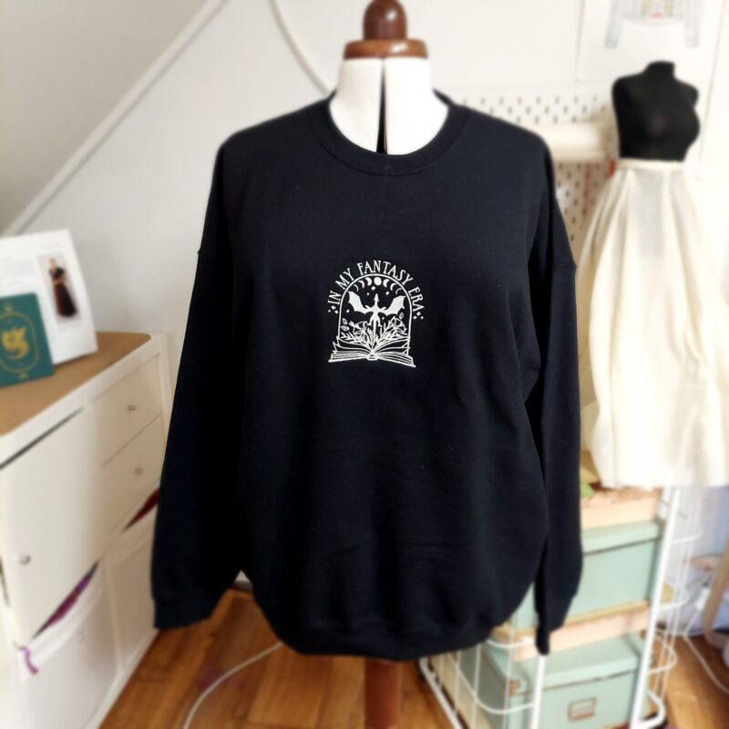 Cozy sweatshirts featuring the phrase "In my Fantasy era" prominently displayed on the chest. Perfect for book lovers!