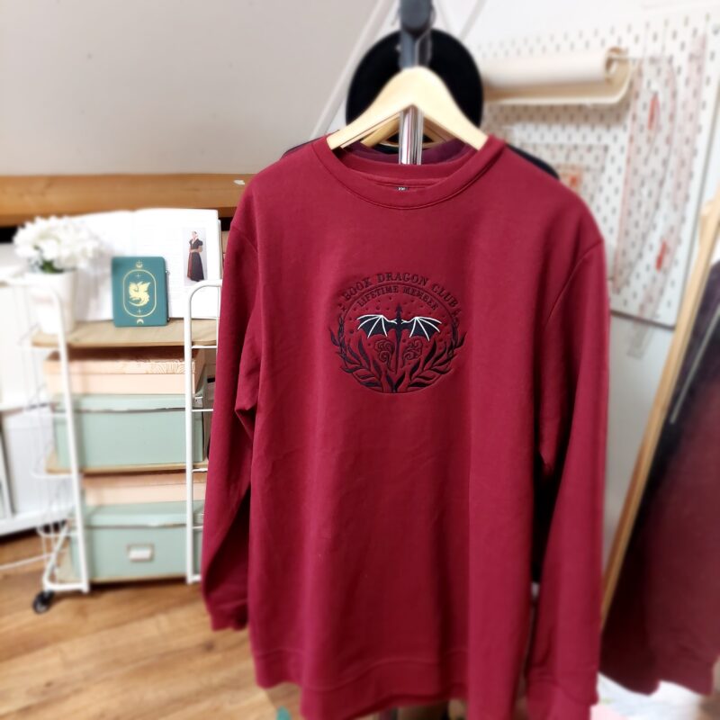 Cozy sweatshirts featuring the phrase "Book Dragon Club Lifetime member " prominently displayed on the chest. Perfect for book lovers!